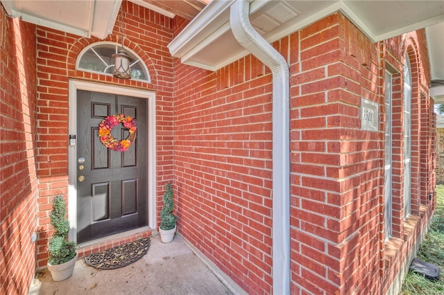 property entrance featuring brick siding