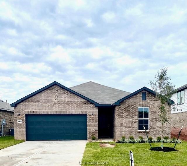 view of front of home with a front lawn and a garage