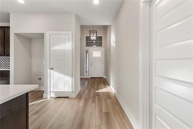 doorway featuring light hardwood / wood-style floors and an inviting chandelier