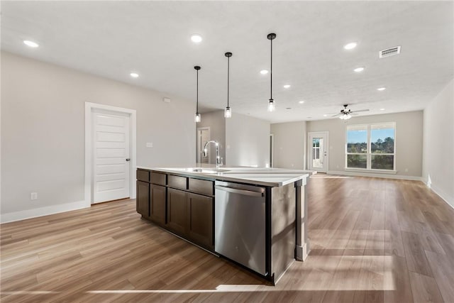 kitchen featuring dishwasher, sink, ceiling fan, an island with sink, and decorative light fixtures