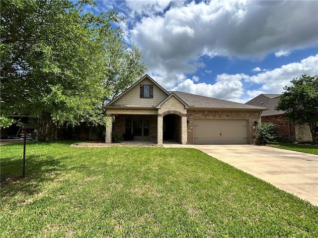view of front of property featuring a front yard, a garage, brick siding, concrete driveway, and stone siding
