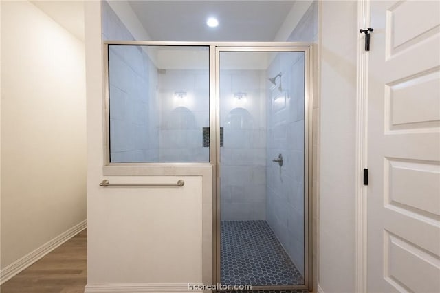 bathroom featuring a shower with door and wood-type flooring