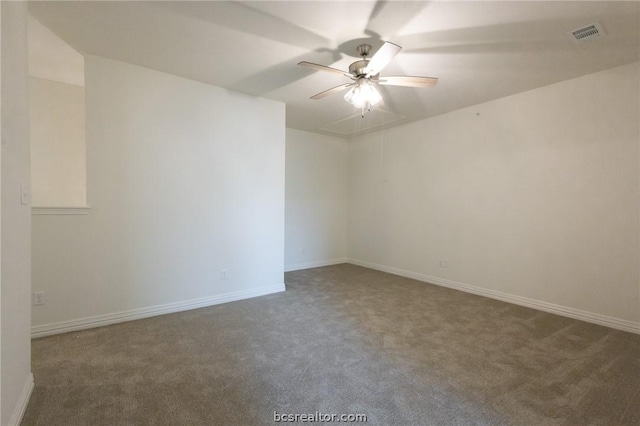 spare room featuring dark colored carpet and ceiling fan