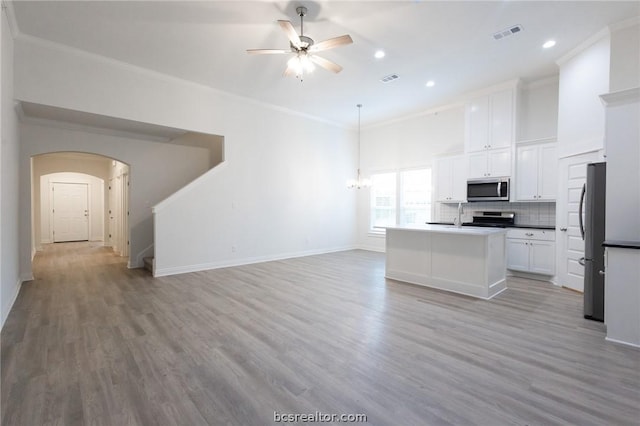 kitchen with ceiling fan, stainless steel appliances, white cabinets, light hardwood / wood-style floors, and a kitchen island