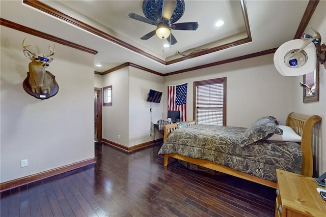 bedroom with hardwood / wood-style floors, baseboards, ceiling fan, crown molding, and a raised ceiling