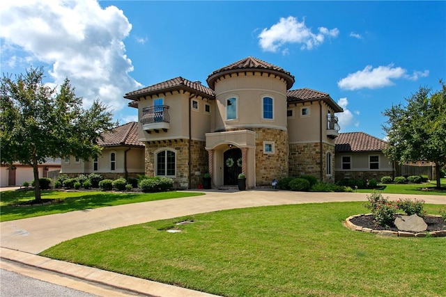 mediterranean / spanish-style home featuring stucco siding, a front yard, a balcony, and driveway