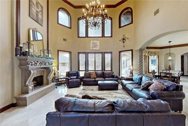 living room with visible vents, ornamental molding, arched walkways, a fireplace, and baseboards