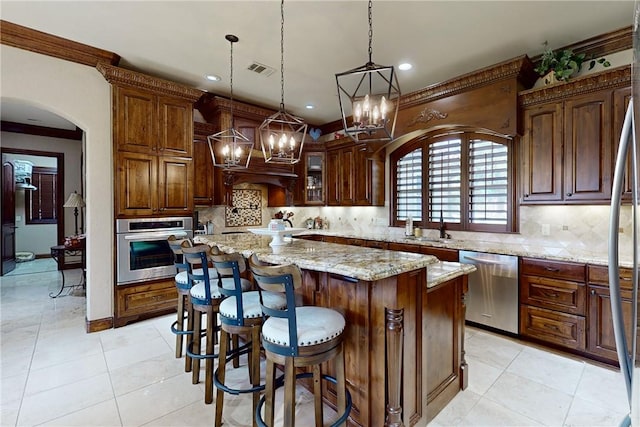 kitchen with visible vents, light tile patterned flooring, arched walkways, stainless steel appliances, and tasteful backsplash