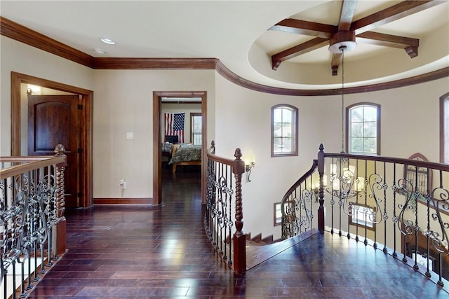 corridor featuring wood finished floors, beamed ceiling, an upstairs landing, and baseboards