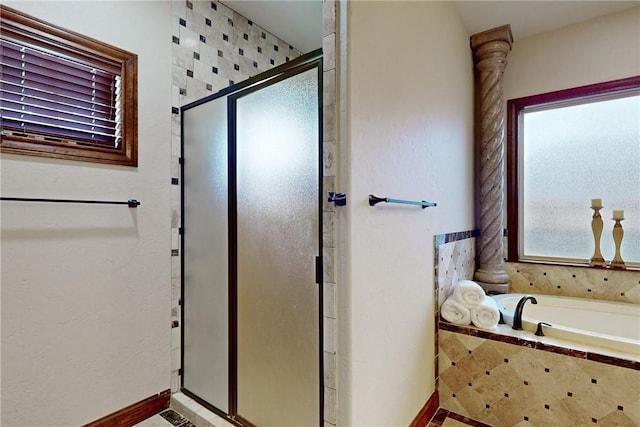 bathroom with a stall shower and a garden tub