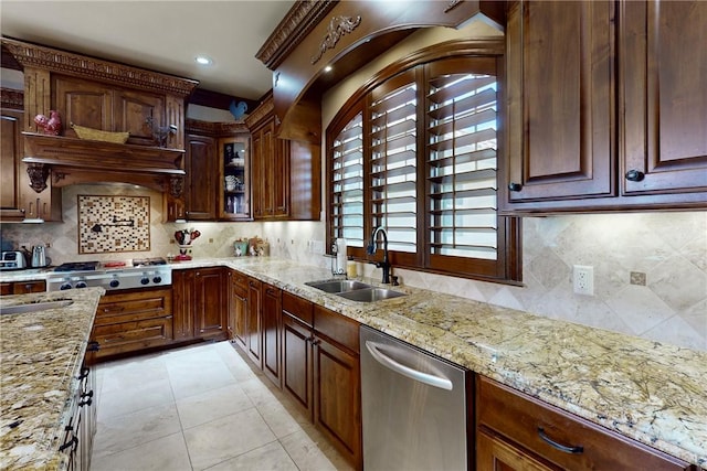 kitchen with a sink, light tile patterned floors, light stone countertops, and stainless steel appliances