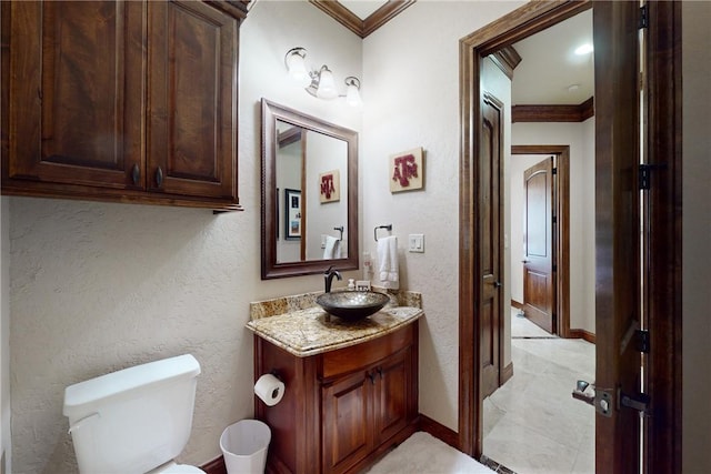 half bathroom featuring vanity, toilet, baseboards, and ornamental molding