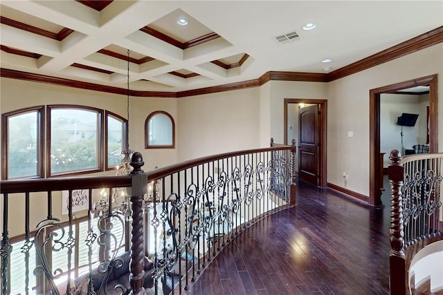 hall featuring visible vents, crown molding, baseboards, wood finished floors, and coffered ceiling