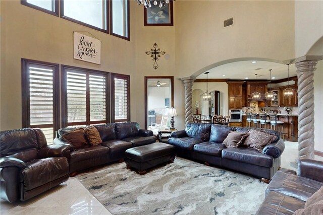 living area with decorative columns, arched walkways, and visible vents