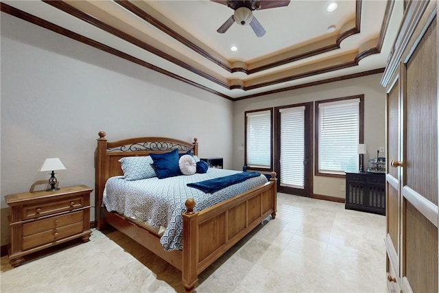 bedroom with a tray ceiling, crown molding, baseboards, and ceiling fan