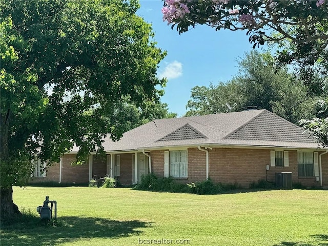 ranch-style home featuring central AC unit and a front yard