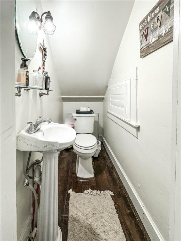 bathroom with hardwood / wood-style floors, toilet, and lofted ceiling