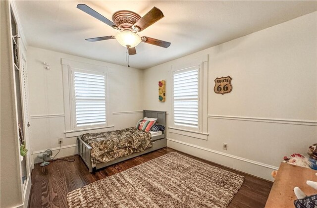 bedroom featuring multiple windows, dark hardwood / wood-style flooring, and ceiling fan