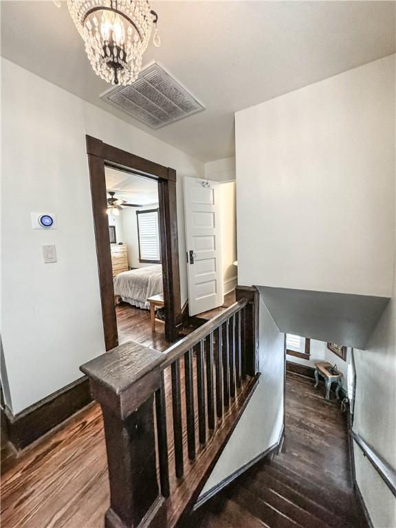 interior space featuring hardwood / wood-style flooring and ceiling fan with notable chandelier