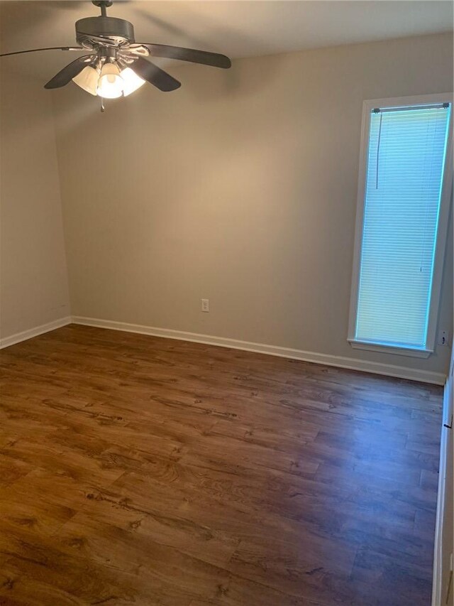 unfurnished room with dark hardwood / wood-style flooring and ceiling fan