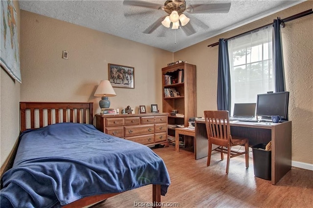 bedroom featuring ceiling fan, a textured ceiling, and light hardwood / wood-style flooring