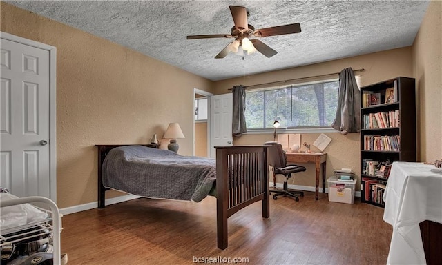 bedroom featuring ceiling fan, wood-type flooring, and a textured ceiling