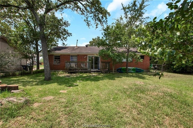 back of property with a yard and a wooden deck