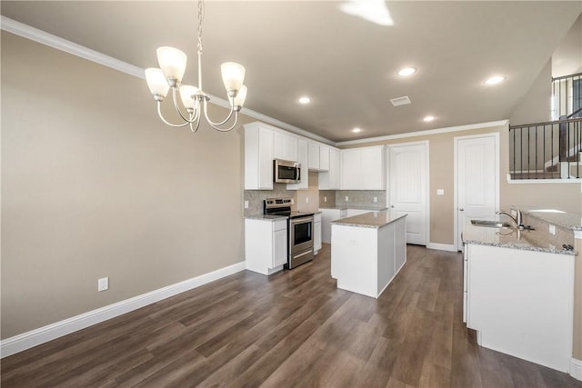 kitchen with a chandelier, stainless steel appliances, hanging light fixtures, white cabinets, and sink