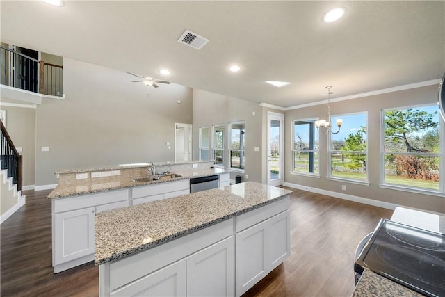 kitchen featuring white cabinets, stainless steel dishwasher, pendant lighting, and a center island