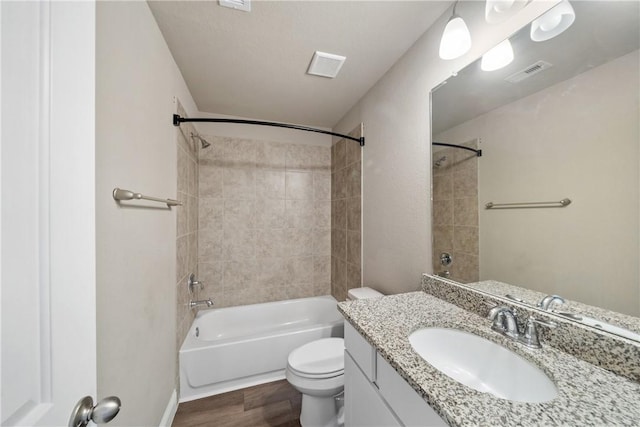 full bathroom with toilet, wood-type flooring, vanity, and tiled shower / bath