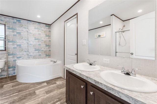 full bathroom with a garden tub, wood finished floors, tile walls, and a sink