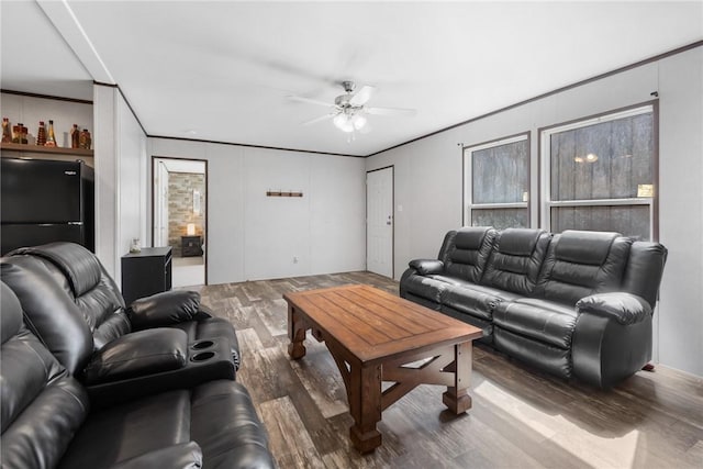 living area featuring wood finished floors, a ceiling fan, and crown molding