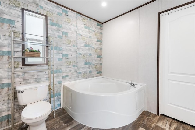 full bath featuring wood finished floors, toilet, a bath, and ornamental molding