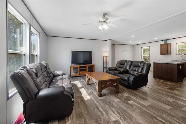 living area with dark wood finished floors, ornamental molding, recessed lighting, and ceiling fan