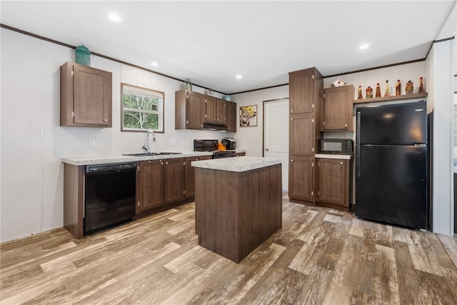 kitchen with black appliances, a sink, crown molding, light wood finished floors, and light countertops