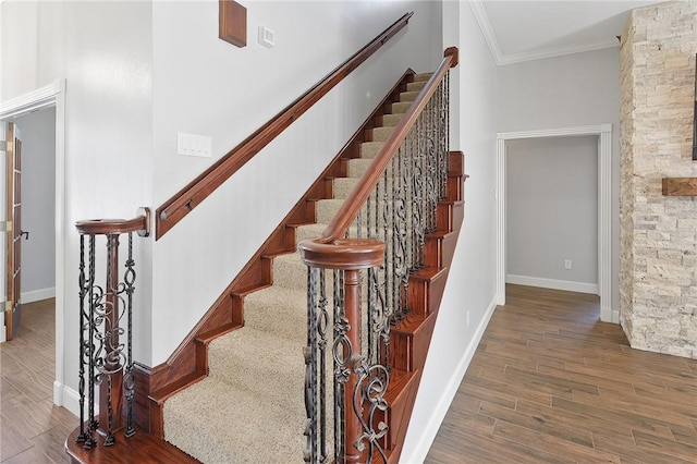 staircase featuring crown molding, a high ceiling, and hardwood / wood-style flooring