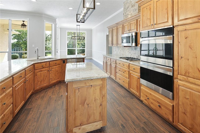 kitchen featuring a center island, dark wood-type flooring, crown molding, hanging light fixtures, and stainless steel appliances