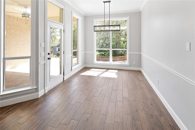 interior space with ceiling fan with notable chandelier, crown molding, and dark wood-type flooring