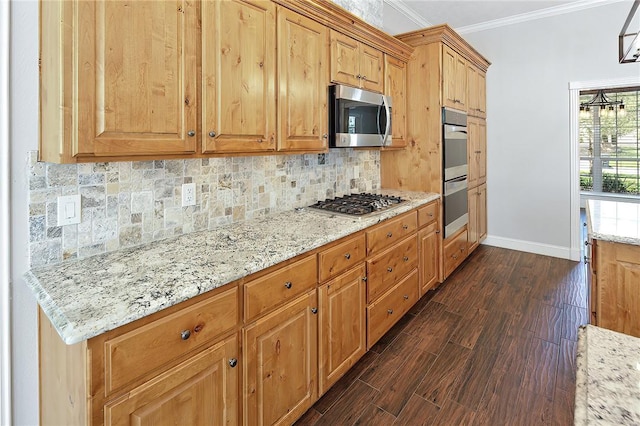 kitchen with light stone countertops, ornamental molding, stainless steel appliances, and dark wood-type flooring