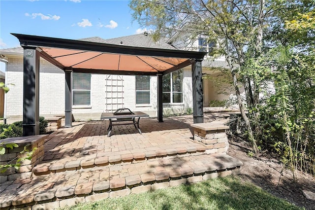 rear view of property featuring a gazebo and a patio