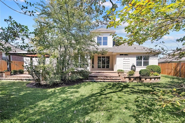 rear view of property with a yard