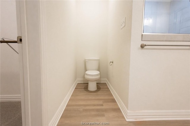 bathroom with hardwood / wood-style floors and toilet