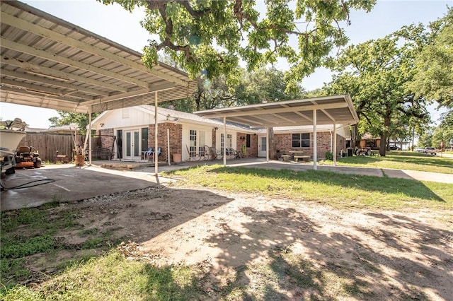885 7th St, Somerville, TX 77879 - back of house with french doors, brick siding, a carport, and a patio