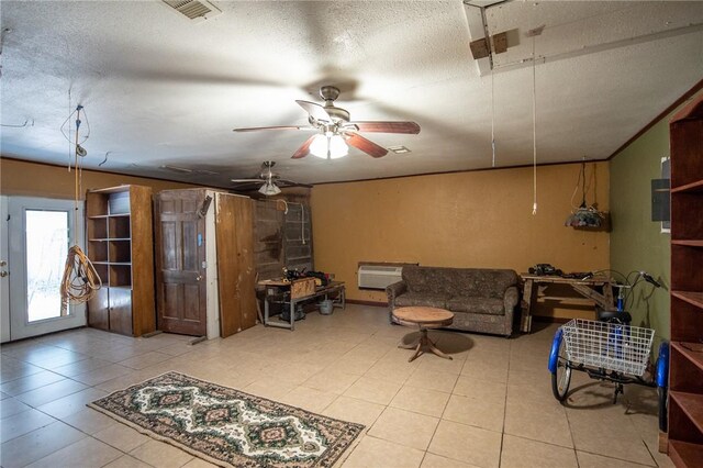 885 7th St, Somerville, TX 77879 - tiled living area featuring a textured ceiling, ceiling fan, a wall mounted AC, and attic access