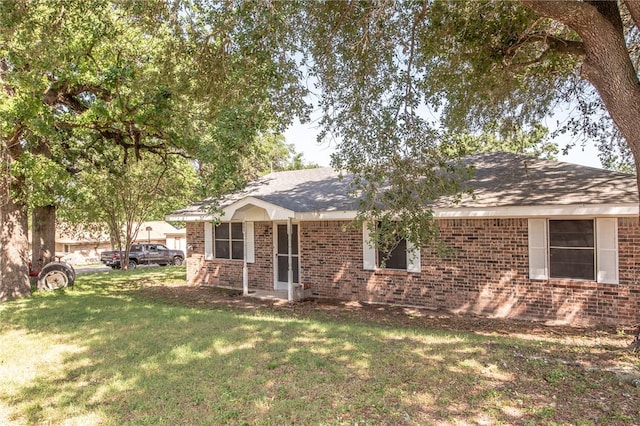 885 7th St, Somerville, TX 77879 - view of front of home with brick siding, a front lawn, and roof with shingles