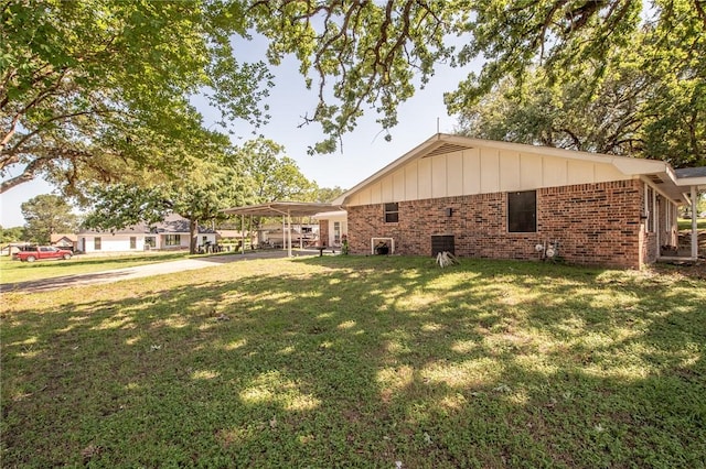 885 7th St, Somerville, TX 77879 - rear view of house with brick siding, a yard, a detached carport, and board and batten siding