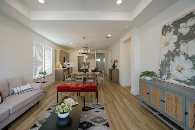 living room featuring a notable chandelier and light wood-type flooring