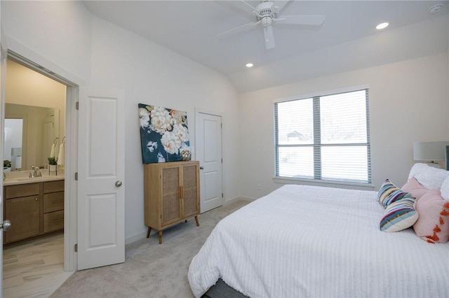 carpeted bedroom with connected bathroom, ceiling fan, and vaulted ceiling