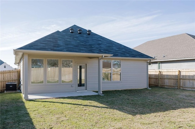 rear view of property featuring a lawn, a patio area, and central AC