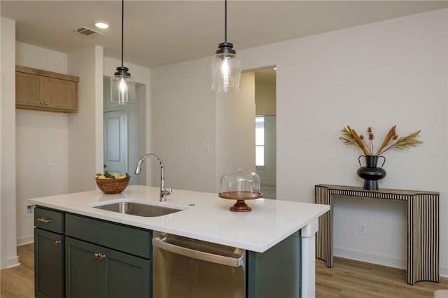 kitchen with pendant lighting, dishwasher, sink, and an island with sink